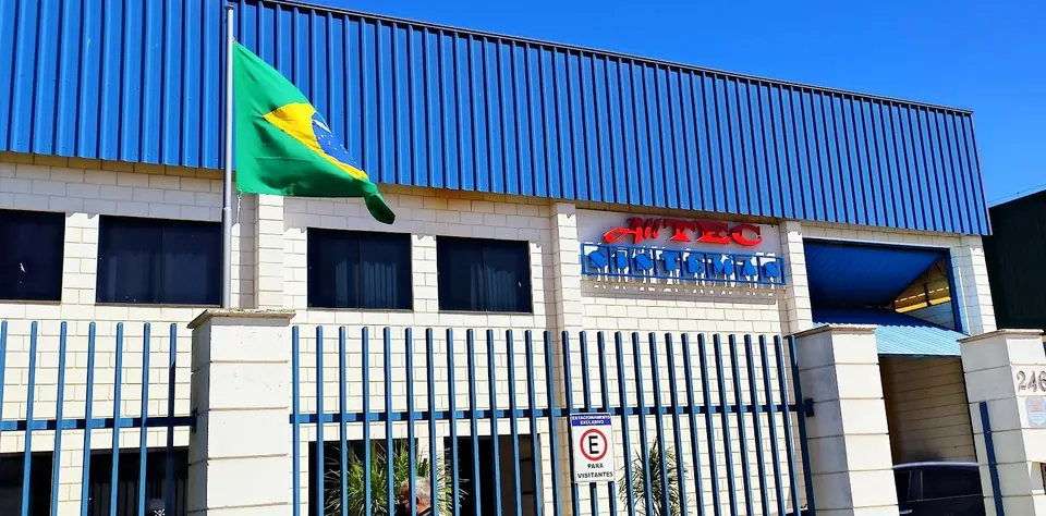 Front of the Alltec Sistemas headquarters in Jundiaí, Brazil, with the company sign and the Brazilian flag