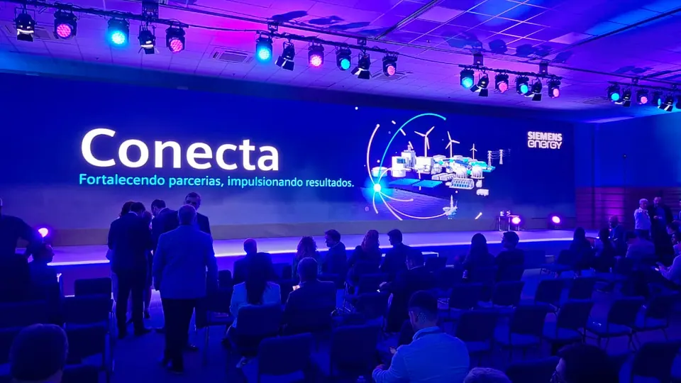 Auditório do Conecta, evento da Siemens Energy: público entre as cadeiras e, no palco, o telão com o lema “Fortalecendo parcerias, impulsionando resultados”