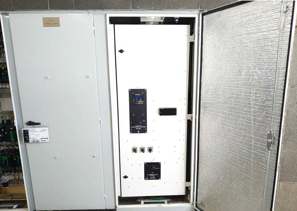 Painel montado com a porta externa aberta, forrada de isolamento térmico aluminizado; na porta interna, o controle de comutador Beckwith e chaves seletoras